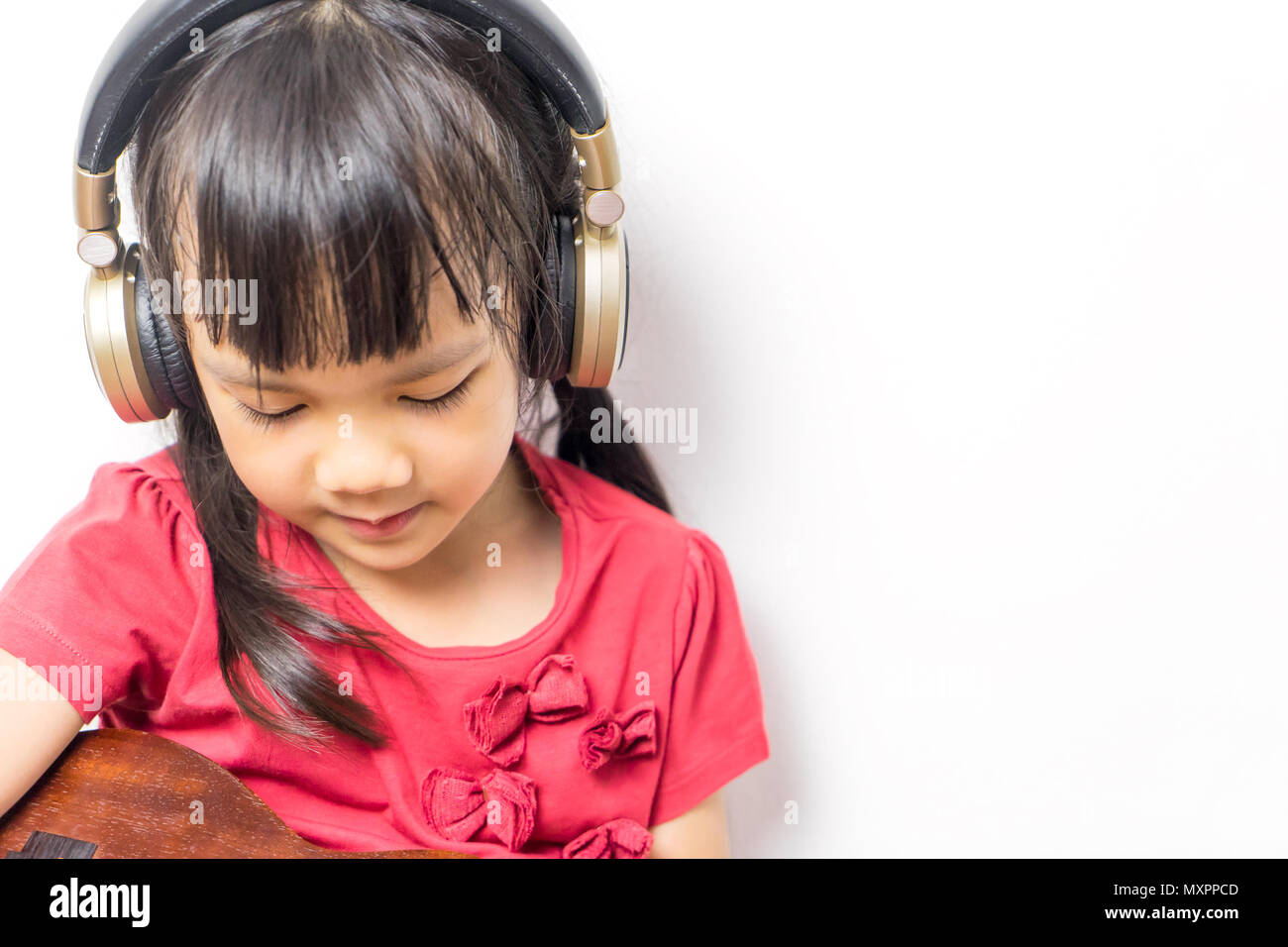 Asiatische Mädchen Musik Gitarre mit Kopfhörer auf weißem Hintergrund. Stockfoto