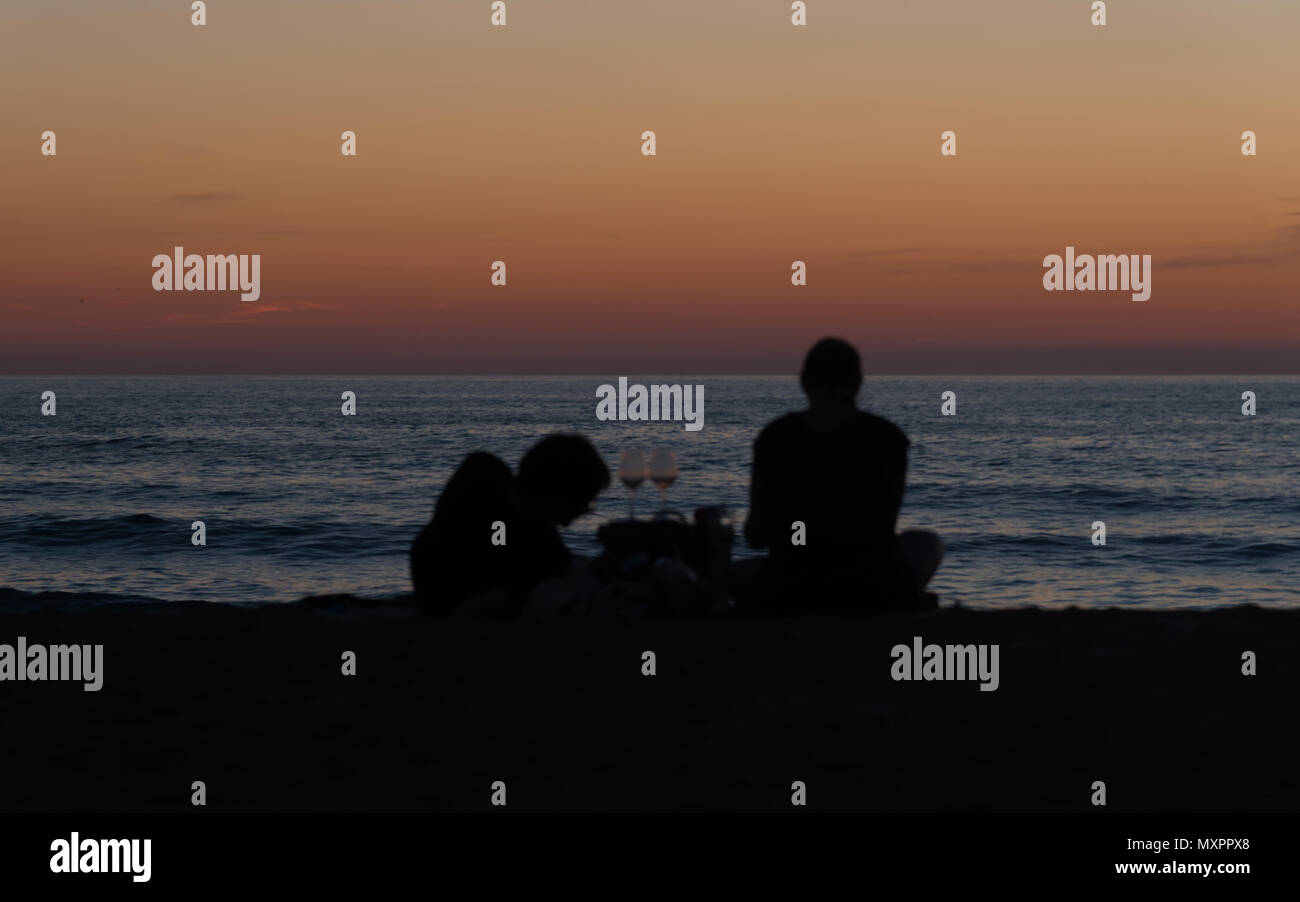 Ein paar Wein trinken und am Strand bei Sonnenuntergang Stockfoto