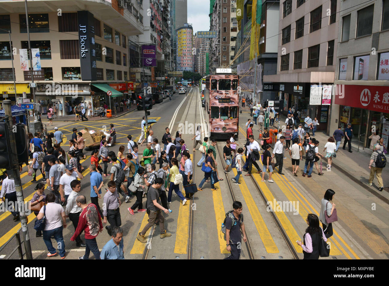 Hong Kong. Menge gehen auf einem Zebrastreifen in Tsing King's Road, Tsing Yi. JP Bücher Buchhandlung Stockfoto