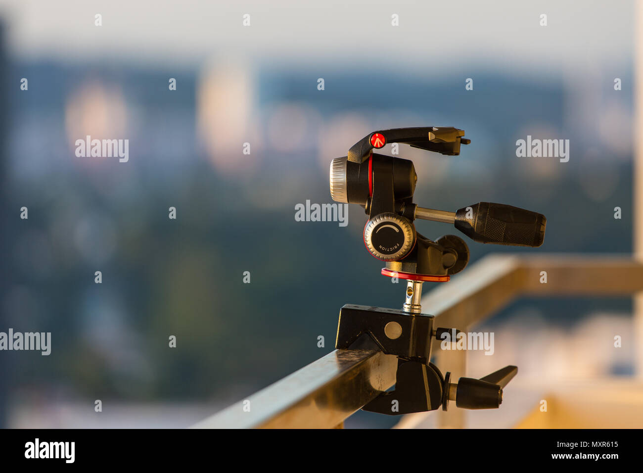 Ein Manfrotto Dreiwege-Stativkopf wird an einer Superklemme in einer Außenumgebung montiert. Stockfoto