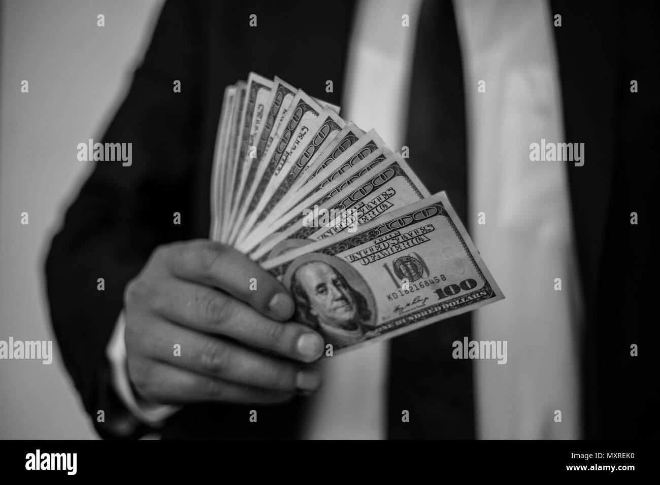 Geschäftsmann mit einer Verbreitung von Cash über einem weißen vintage Hintergrund Stockfoto