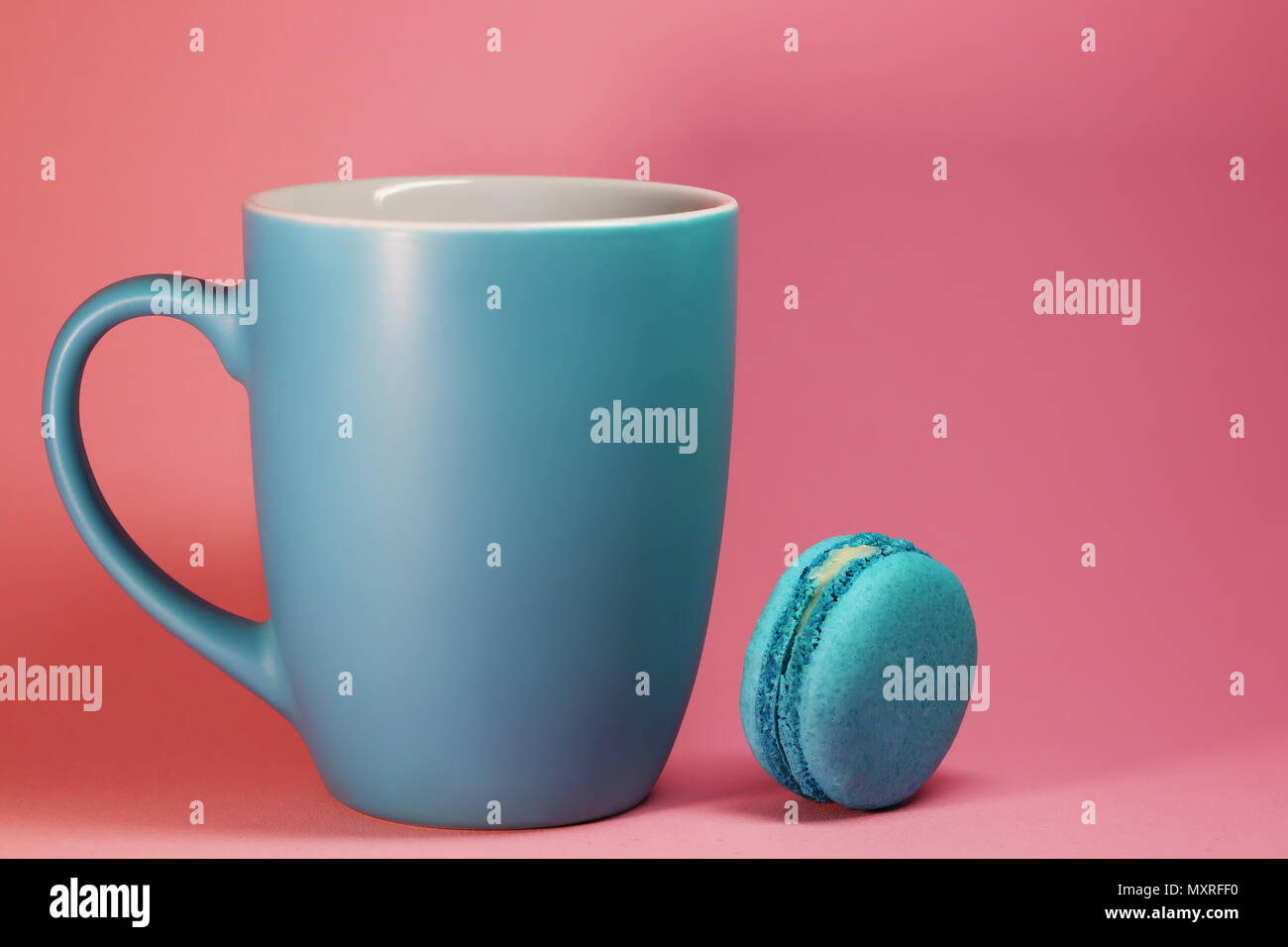Blaue Tasse Tee auf rosa Hintergrund mit makronen Stockfoto