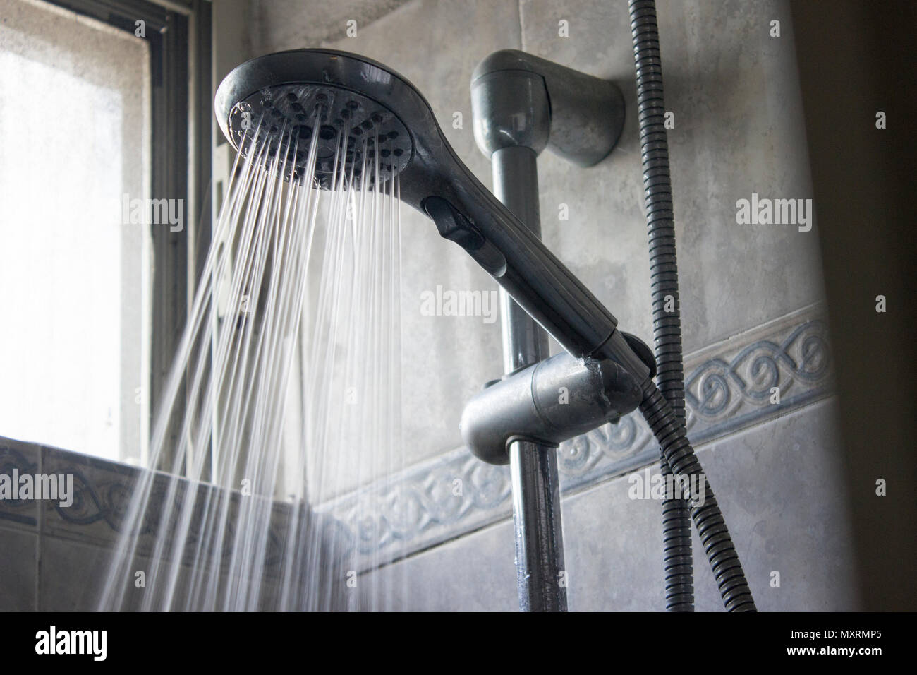 Hoher Druck Wasser Sprühstrahl Gießen von einem Handheld Duschkopf. Stockfoto