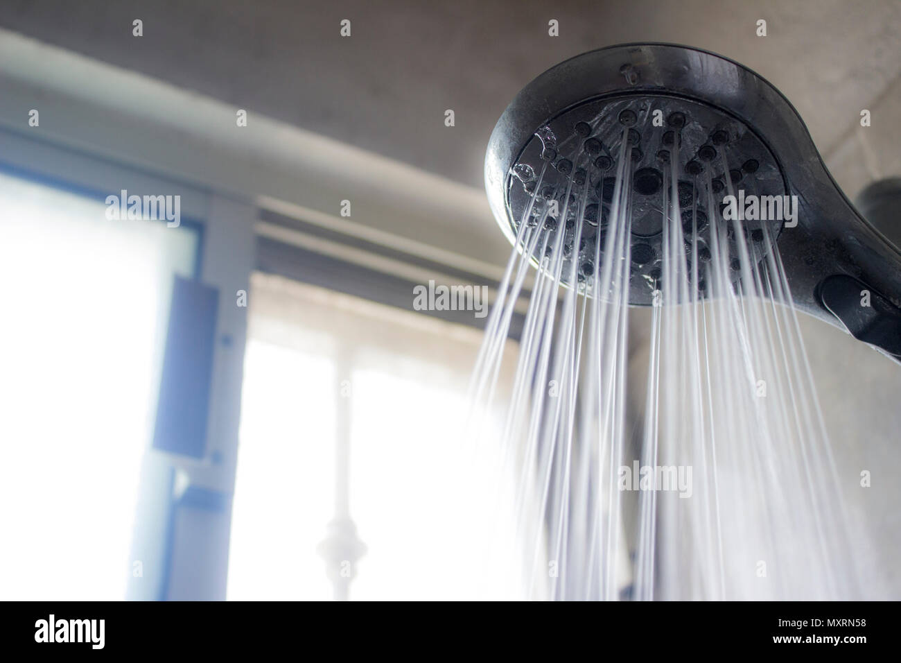 Nahaufnahme einer Duschkopf und ein Wasserstrahl Gießen im Spritzbild. Stockfoto