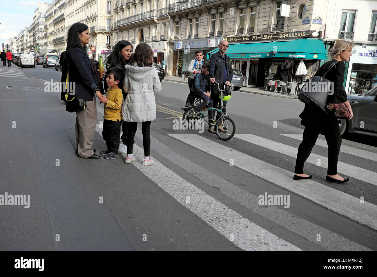 Eltern und Kinder nach Hause gehen an einem Nachmittag nach der Schule zu Fuß und auf dem Fahrrad in der Nähe von einem Zebrastreifen in Paris Frankreich KATHY DEWITT Stockfoto