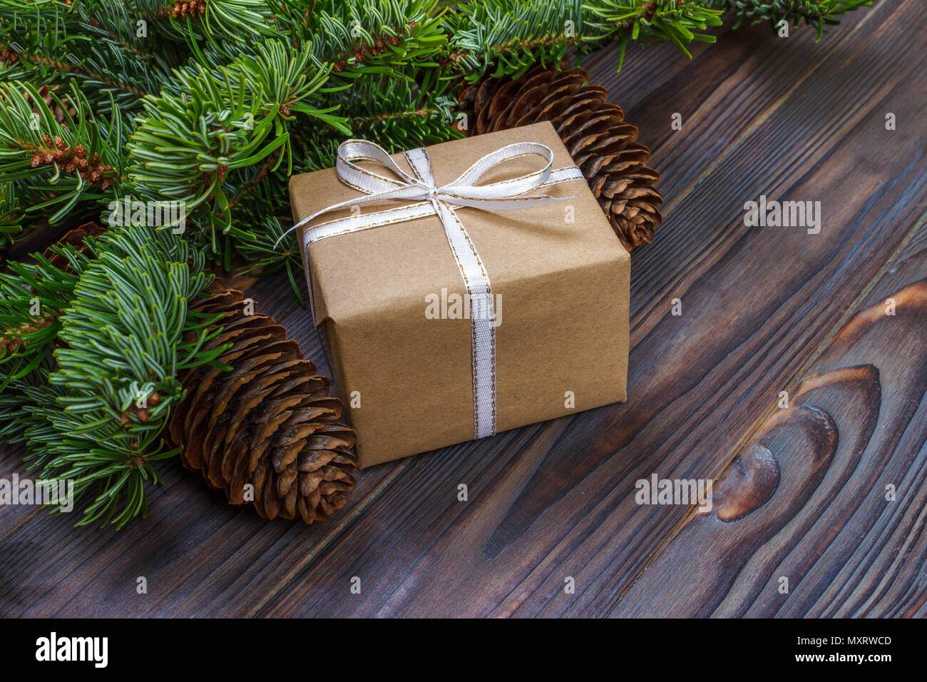 Weihnachten Komposition. Weihnachten Geschenk, gestrickte Decke, Tannenzapfen, tannenzweigen auf hölzernen weißen Hintergrund. Flach, Ansicht von oben. Stockfoto