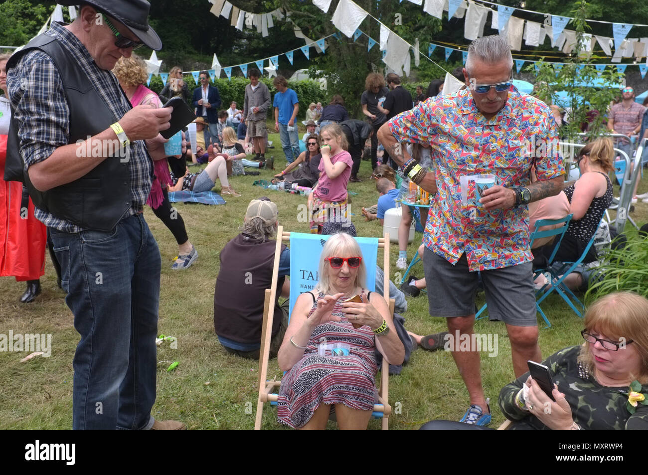 Eine Gruppe von älteren Menschen auf ihren Handys auf einem Festival Stockfoto