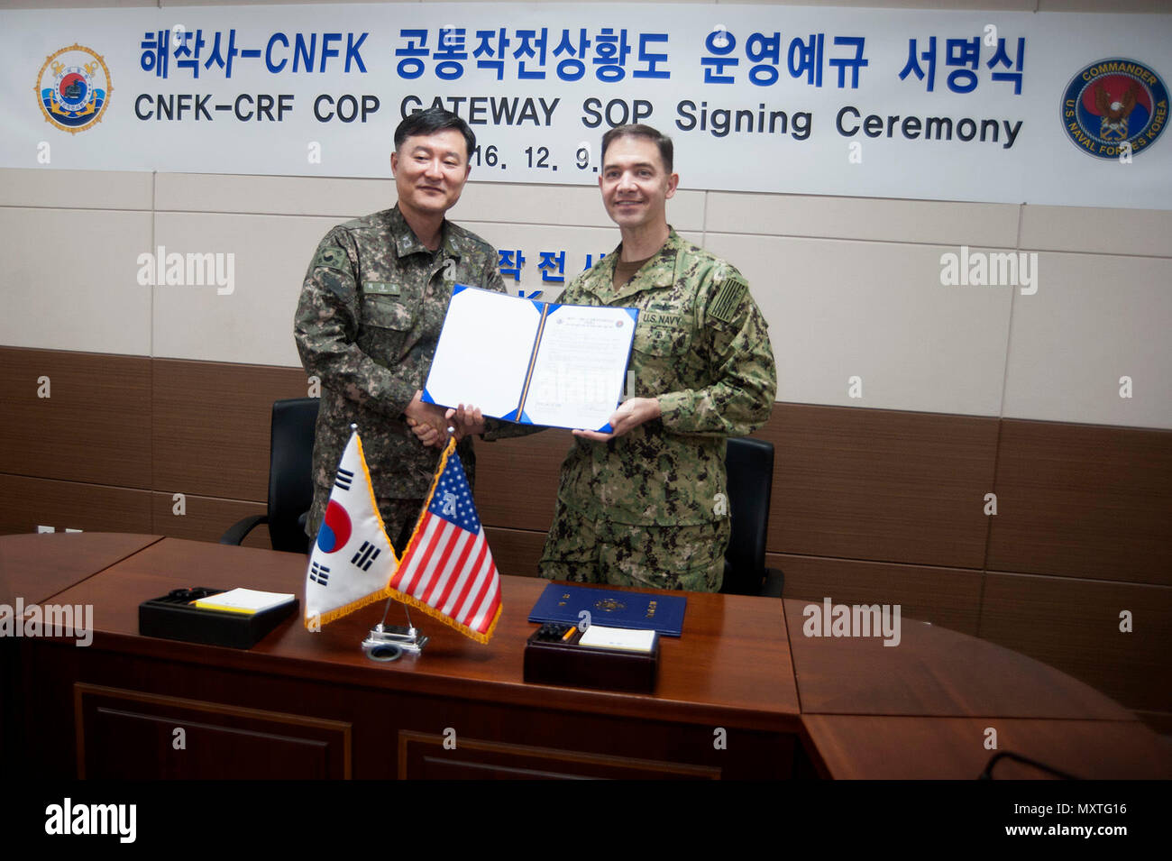 161209-N-UL-BUSAN 717-008, Republik Korea (31. 09, 2016) - Hintere Adm. Brad Cooper, dem Kommandeur der US Naval Forces Korea, und hinten Adm. Choi, Sung-Mok, der Stabschef für die Republik Korea Flotte, unterzeichnen ein standard operating procedure Vereinbarung, die regelt, um gemeinsam die bilateralen gemeinsamen operativen Bild, das eine identische Darstellung von relevanten operativen Informationen, die von mehr als einem Befehl geteilt wird die Bedienung und Wartung ein Verfahren für beide Befehle. (U.S. Marine Foto von Leutnant Josua Kelsey) Stockfoto