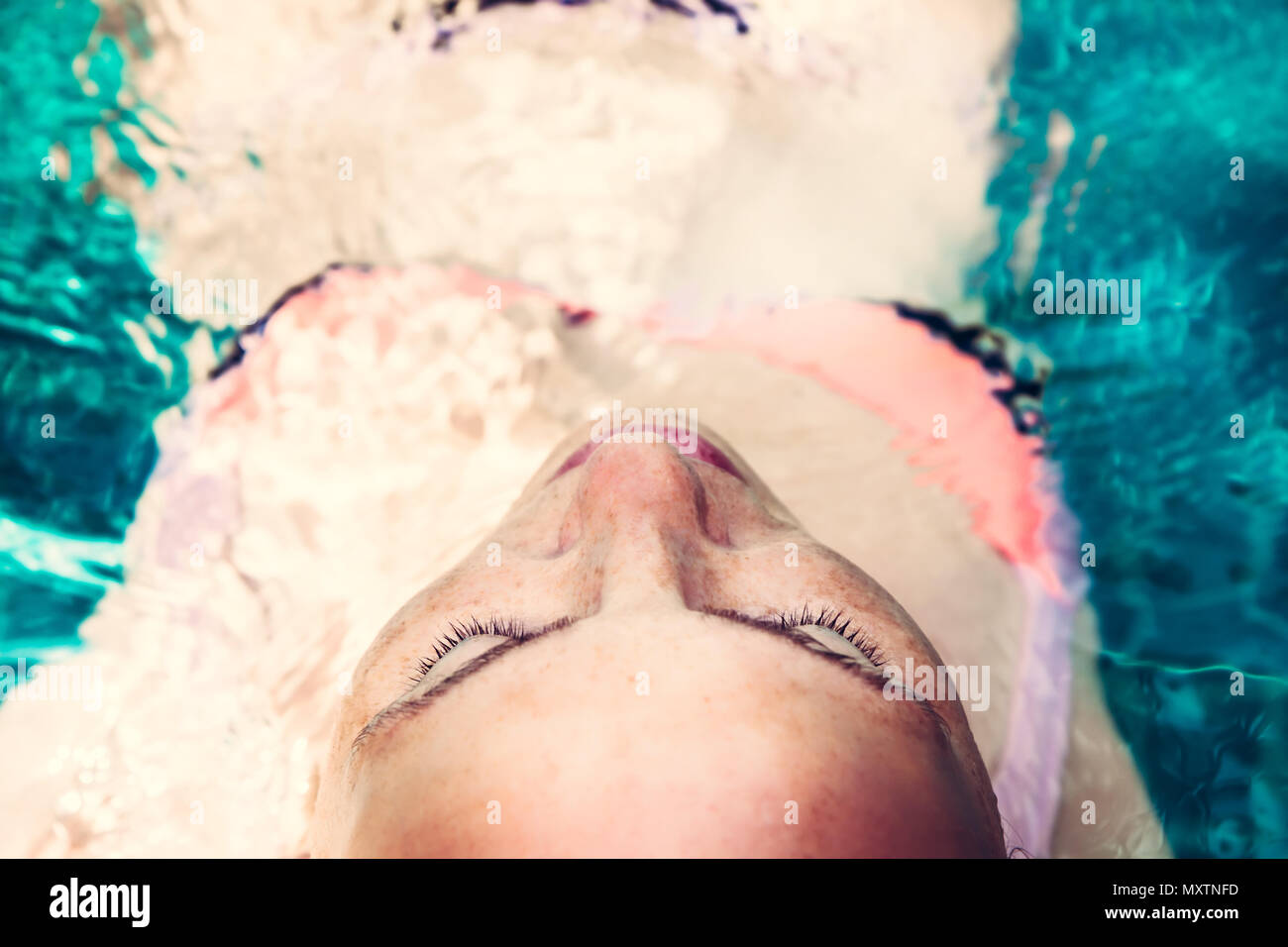 Schöne Frau Relaxen im Pool, türkisfarbenem Wasser geschlossenen Augen Genuss spa Behandlung Konzept Stockfoto