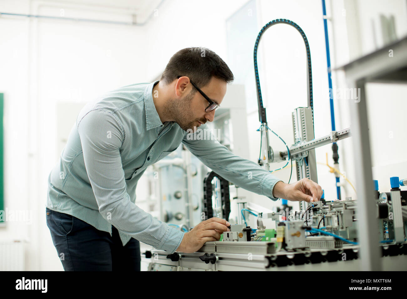Hübscher junger Mann, der in der elektronischen Werkstatt Stockfoto