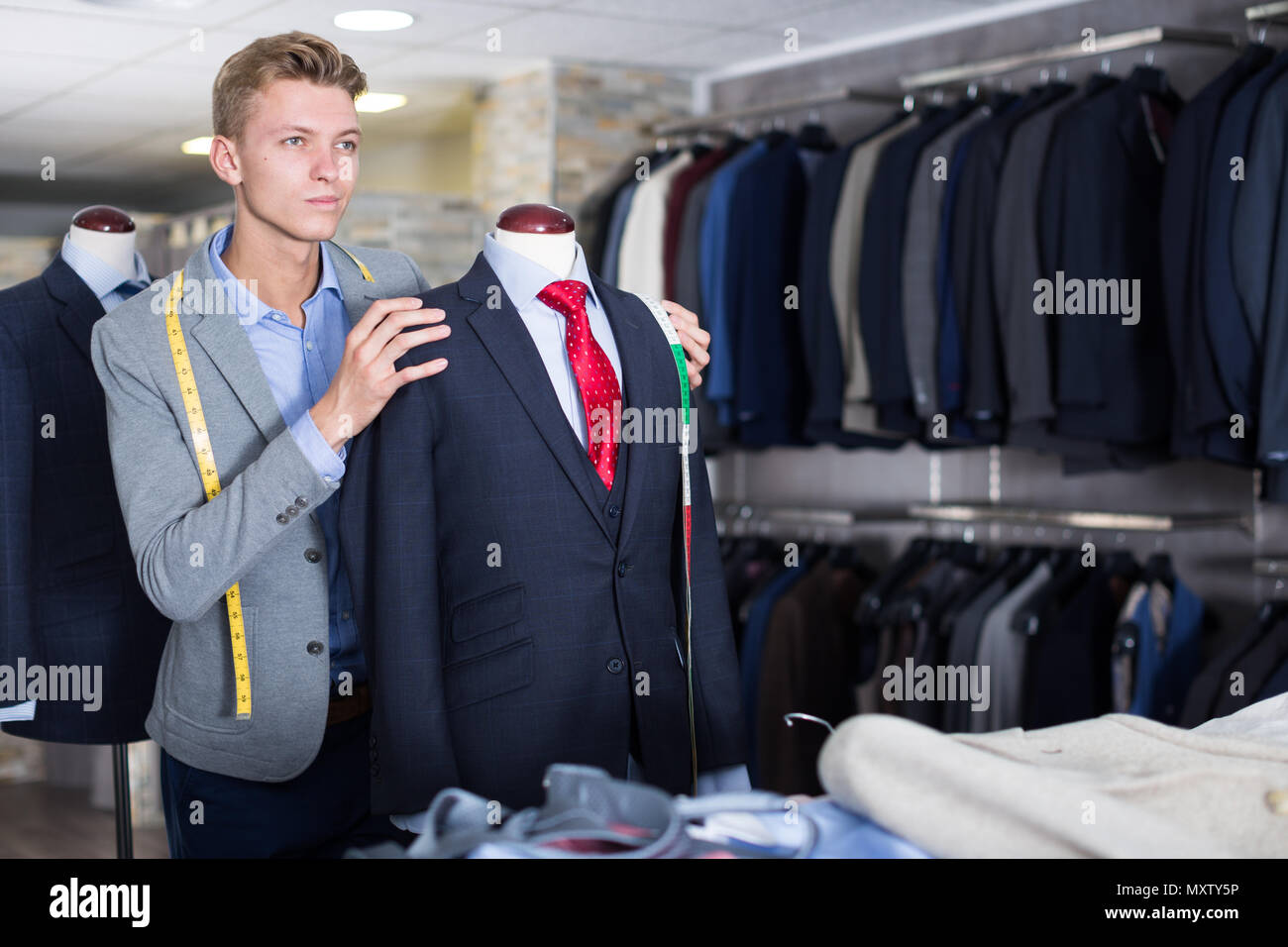 Verkäufer im Geschäft Kleidung messen Jacke im Dress Shop Stockfotografie -  Alamy