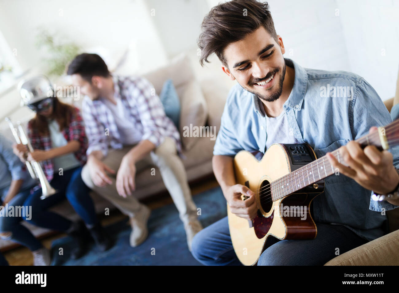 Freunde zu Hause genießen, Singen und Gitarre Spielen Stockfoto