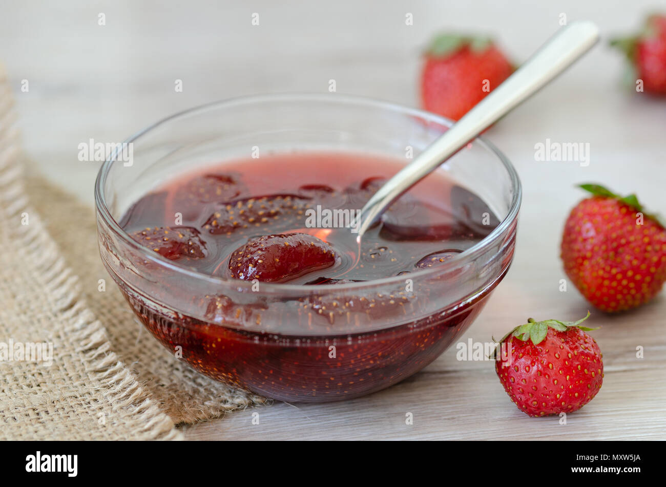 Glas Erdbeermarmelade und Erdbeere auf dem Tisch. Stockfoto