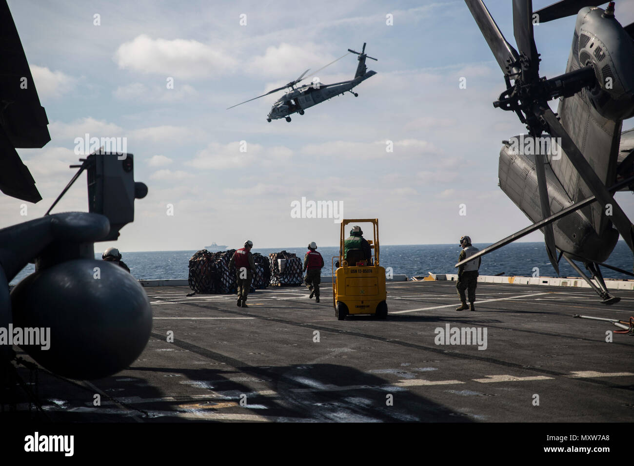 Marines mit dem 24 Marine Expeditionary Unit Hubschrauber support team Erholen liefert sank von einem Sikorsky MH-60S Seahawk an Bord der USS Mesa Verde LPD (19), während eine vertikale Nachschub für den Amphibischen bereit Gruppe Marine Expeditionary Unit Übung Dez. 8, 2016. Während der dreiwöchigen Ausbildung evolution, Marines wird eine breite Palette von Maßnahmen und Szenarien die Verbesserung der Interoperabilität und amphibische Kriegsführung Fähigkeiten mit ihren Marine Pendants bekämpfen. Re-liefert auf See sind lebenswichtig für die bataan Amphibious Ready Gruppe selbst unterstützen, während im Gange. (U.S. Marine Corps Foto von Cpl. Stockfoto