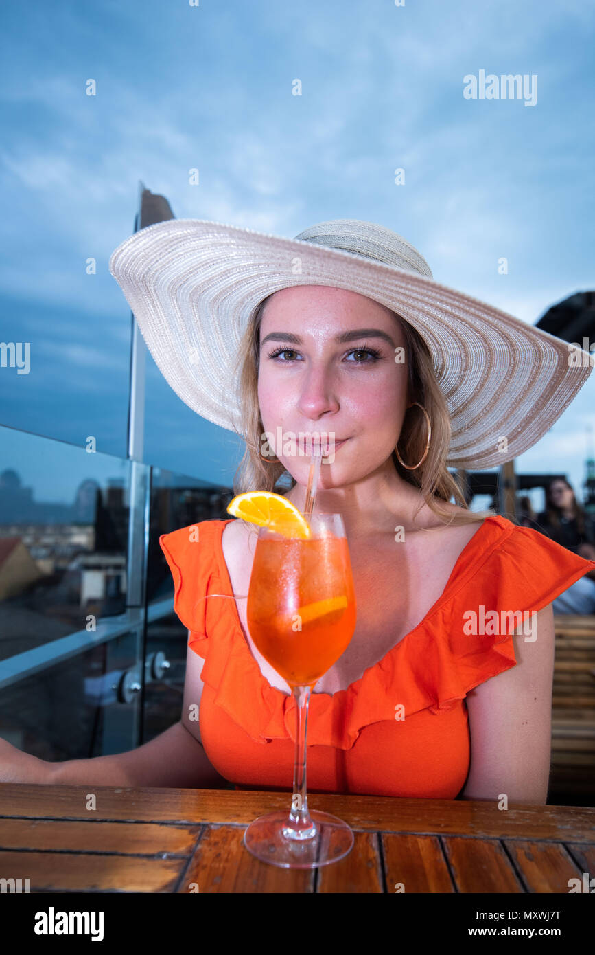 Mode und Lifestyle blogger Andreea Rasclescu an der Bar auf der Dachterrasse in Oxford, die Varsity Club, trinken ein Glas Orange Aperol Ihr aktuelles Outfit anpassen. Stockfoto