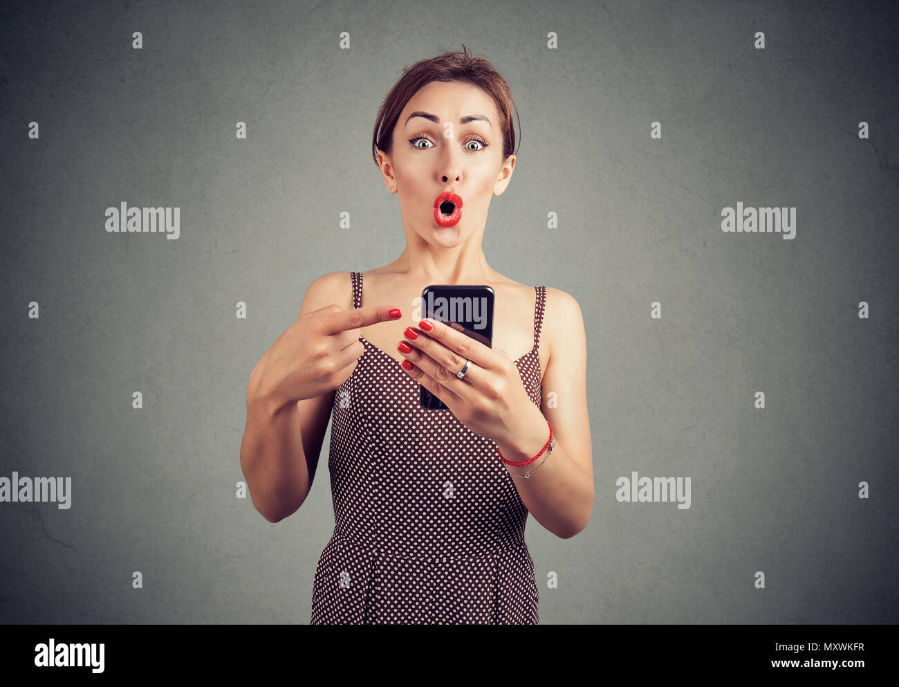Schockiert ironische Mädchen, dass Smartphone und zeigt Es Gesonnte mit dem Brechen von von Nachrichten Stockfoto