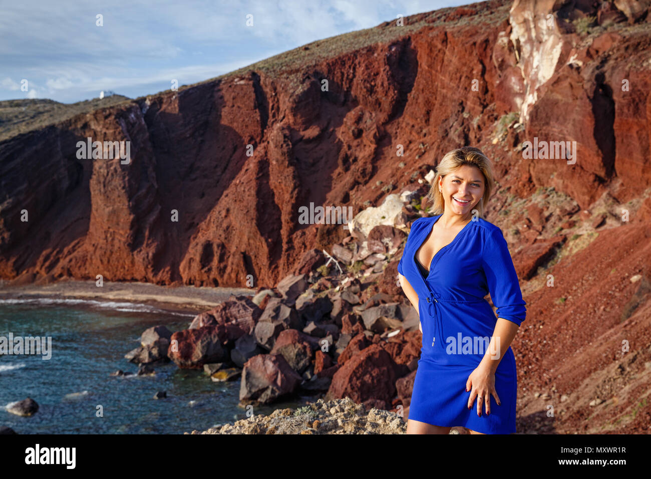 Junge Frau auf Rot, vulkanischen Strand von Santorini, Griechenland Stockfoto