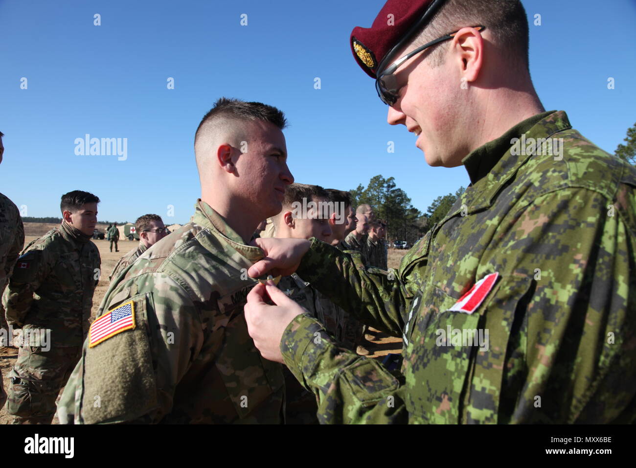 Kapitän Andrew Adach, Kanadische Armee Advanced Warfare Center, Stifte US-Armee Pfc. Coty Mikita, 1-508, 3. Brigade, 82nd Airborne Division, seinen Canadian jump Wings erwarb er bei einem Betrieb für die 19. jährlichen Randy Oler Memorial Betrieb Spielzeug Fallen, bewirtet durch die US-Armee die zivilen Angelegenheiten & psychologische Operations Command (Airborne), auf Luzon Drop Zone, N.C., 10.12.2016. Betrieb Spielzeug Drop ist der weltweit größte kombinierten Betrieb und gemeinsame Aus- und Fortbildung mit acht Partner - nation Fallschirmjäger teilnehmen. (U.S. Armee Foto von SPC. Lisa Velazco/Freigegeben) Stockfoto