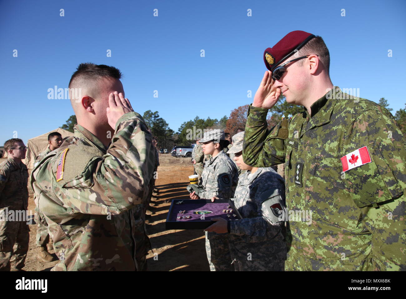 Us-Armee Pfc. Coty Mikita, 1-508, 3. Brigade, 82nd Airborne Division, würdigt Kapitän Andrew Adach, Kanadische Armee Advanced Warfare Center, nachdem er sein Canadian jump Wings er während ein Betrieb für die 19. jährlichen Randy Oler Memorial Betrieb Spielzeug Drop erwarb, bewirtet durch die US-Armee die zivilen Angelegenheiten & psychologische Operations Command (Airborne), auf Luzon Drop Zone, N.C., 10.12.2016. Betrieb Spielzeug Drop ist der weltweit größte kombinierten Betrieb und gemeinsame Aus- und Fortbildung mit acht Partner - nation Fallschirmjäger teilnehmen. (U.S. Armee Foto von SPC. Lisa Velazco/Freigegeben) Stockfoto