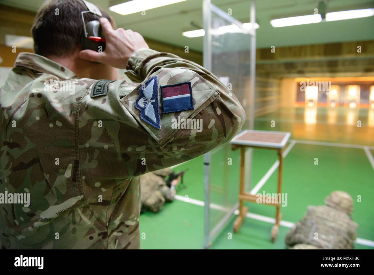 Ein Mitglied des britischen Joint European Training Team setzt auf sein Gehör Schutz vor einer Sitzung mit L 85 A2 Gewehren auf die Schulung Support Center Benelux 25 m Reichweite im Innenbereich, auf chièvres Air Base, Belgien, November 30, 2016 zu starten. Die britischen Truppen mit lokalen Einheiten, die unter Aufsicht der britischen Joint European Training Team stationiert. (U.S. Armee Foto von visuellen Informationen Spezialist Pierre-Etienne Courtejoie) Stockfoto