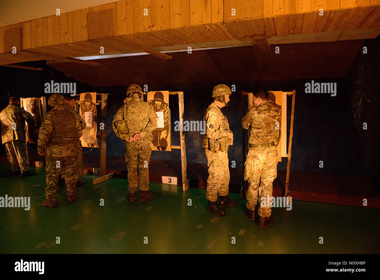 Mitglieder der Britischen Streitkräfte zugeordnet zu den lokalen Einheiten ihre Nullstellen Zielvorgaben nach dem Schießen mit ihren L 85 A2 Gewehren auf die Schulung Support Center Benelux 25 m Reichweite im Innenbereich, auf chièvres Air Base, Belgien, November 30, 2016 überprüfen. Die britischen Truppen unter Aufsicht der britischen Joint European Training Team ausgebildet. (U.S. Armee Foto von visuellen Informationen Spezialist Pierre-Etienne Courtejoie) Stockfoto