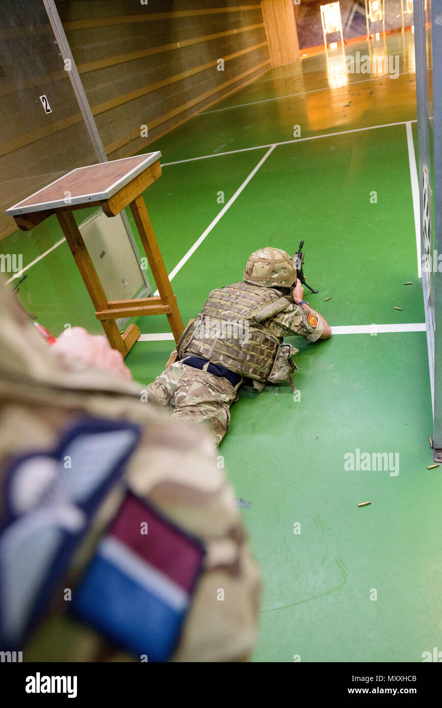 Die Royal Air Force Mitglied des Gemeinsamen Europäischen Training Team überwacht die britischen Streitkräfte zu den lokalen Einheiten zugeordnet, da sie ihre L 85 A2 Gewehren auf die Schulung Support Center Benelux 25 Fire-Meter Reichweite im Innenbereich, auf chièvres Air Base, Belgien, November 30, 2016. Die britischen Truppen unter Aufsicht der britischen Joint European Training Team ausgebildet. (U.S. Armee Foto von visuellen Informationen Spezialist Pierre-Etienne Courtejoie) Stockfoto