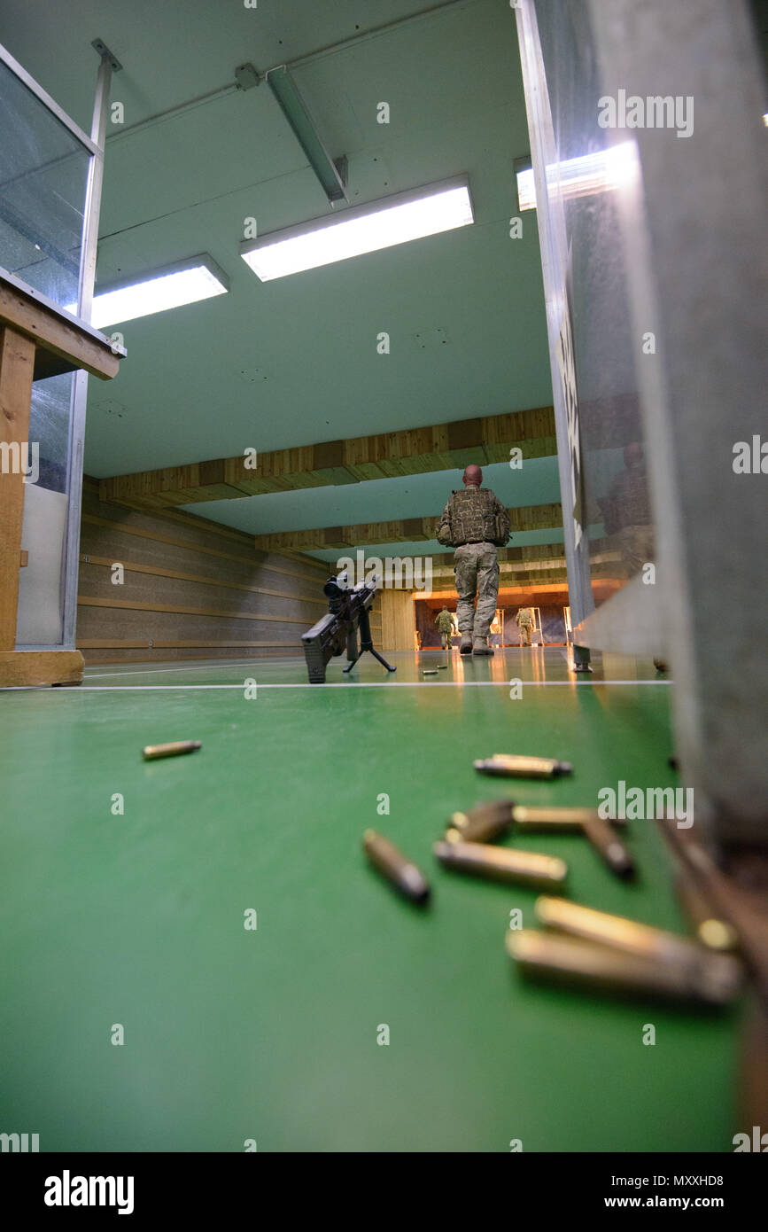 Ein Mitglied der Britischen Streitkräfte zu einem lokalen Gerät zugeordnet ist, Spaziergänge in Richtung der Nullabgleich Zielvorgaben nach dem Shooting mit einem L 85 A2 Gewehr an der Schulung Support Center Benelux 25 m Reichweite im Innenbereich, auf chièvres Air Base, Belgien, November 30, 2016. Die britischen Truppen unter Aufsicht der britischen Joint European Training Team ausgebildet. (U.S. Armee Foto von visuellen Informationen Spezialist Pierre-Etienne Courtejoie) Stockfoto