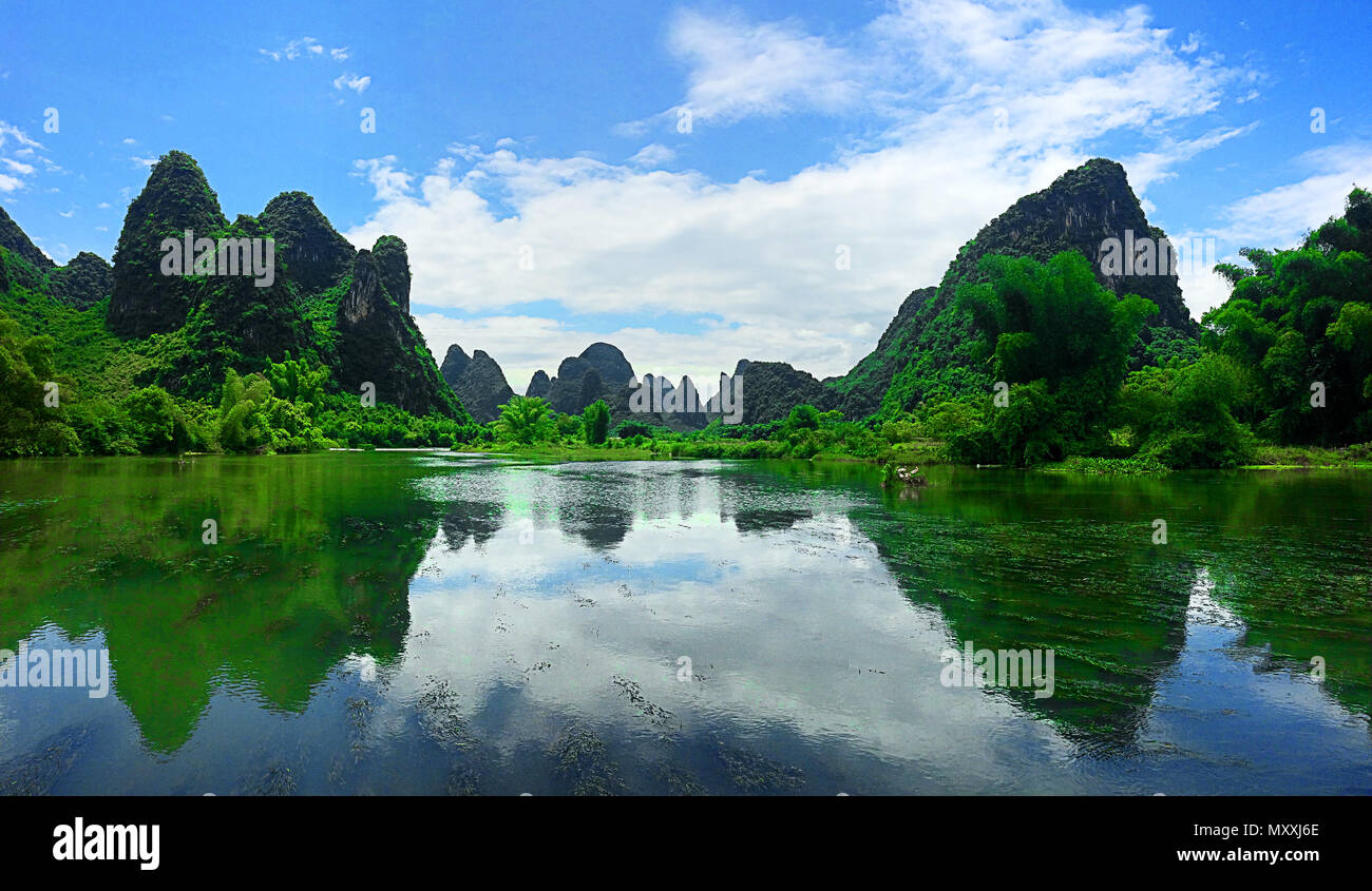 Zerklüfteten grünen Spitzen von Yangzhou China im Wasser widerspiegelt Stockfoto