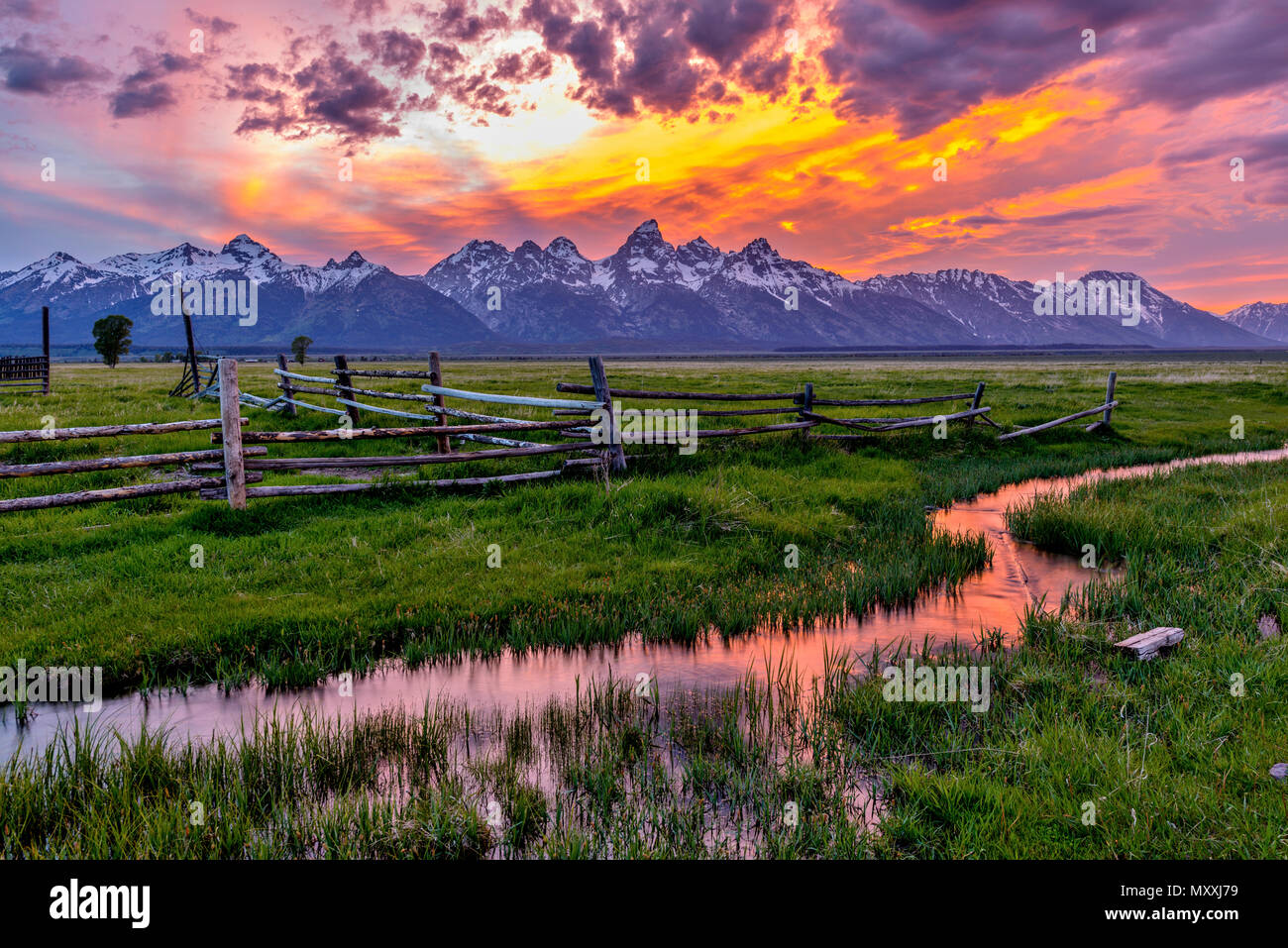 Golden feurigen Sonnenuntergang am Grand Teton - eine Feder Sonnenuntergang am Teton Range, von einem verlassenen Old Ranch in Mormonischen Reihe gesehen, im Grand Teton National Park, USA. Stockfoto