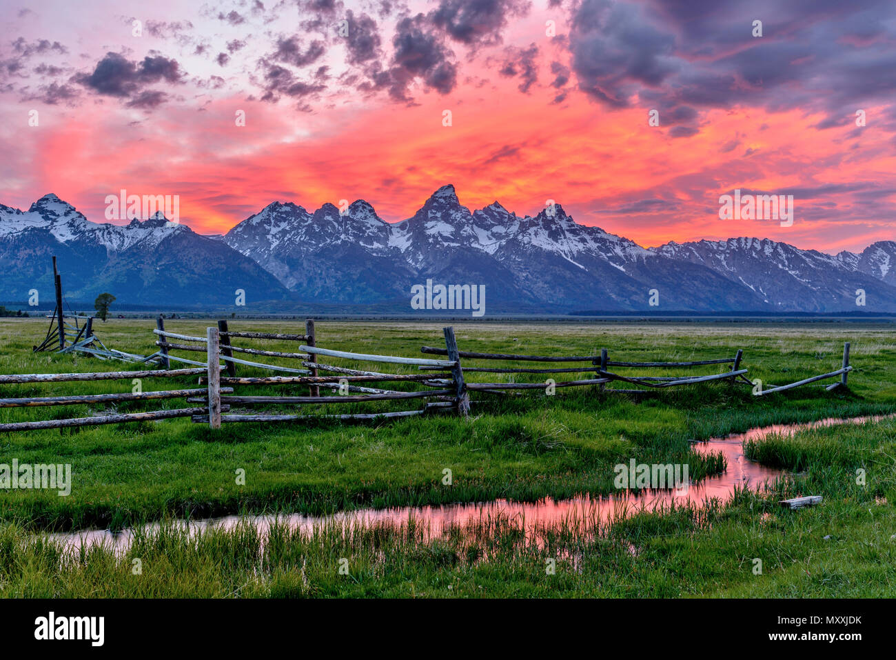 Sonnenuntergang am Grand Teton - Panoramablick auf einen spektakulären Sonnenuntergang am Teton Range, aus einem alten Ranch in Mormonischen Reihe, Grand Teton National Park, USA gesehen. Stockfoto