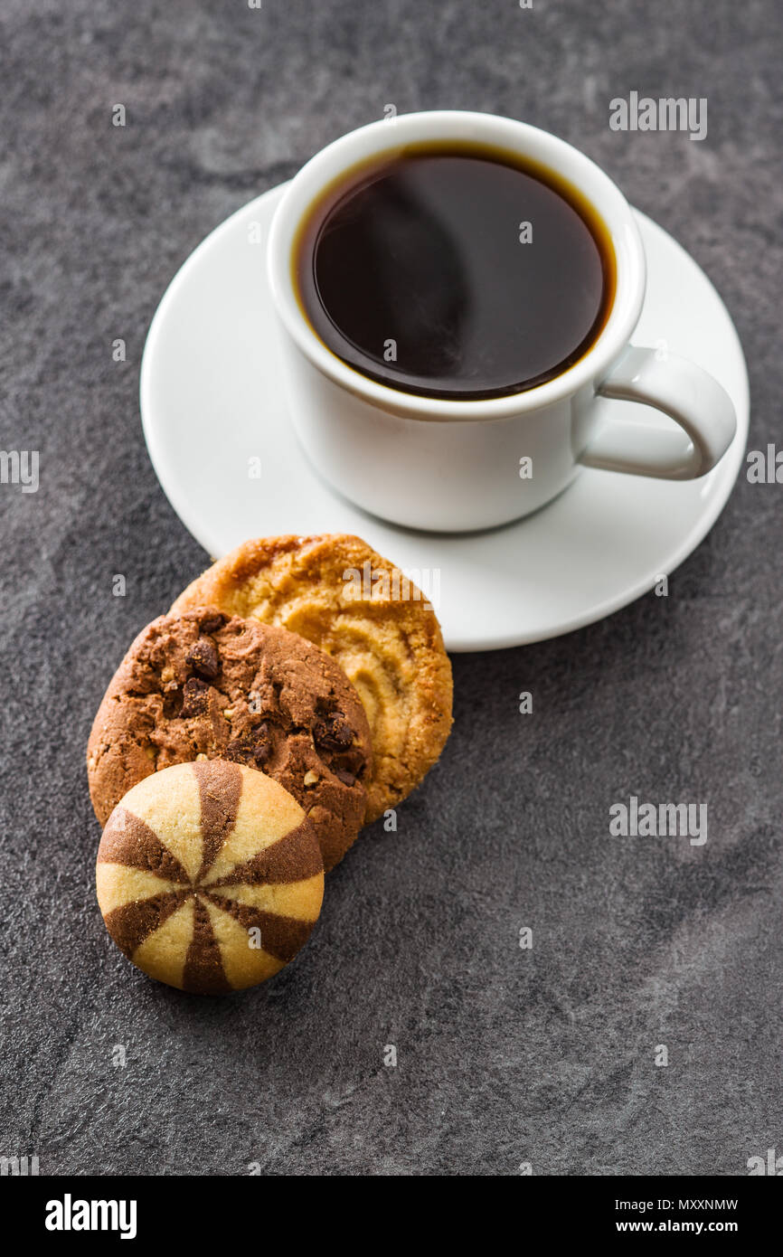 Tasse Kaffee und süßes Cookies auf Schwarzen Tisch. Stockfoto