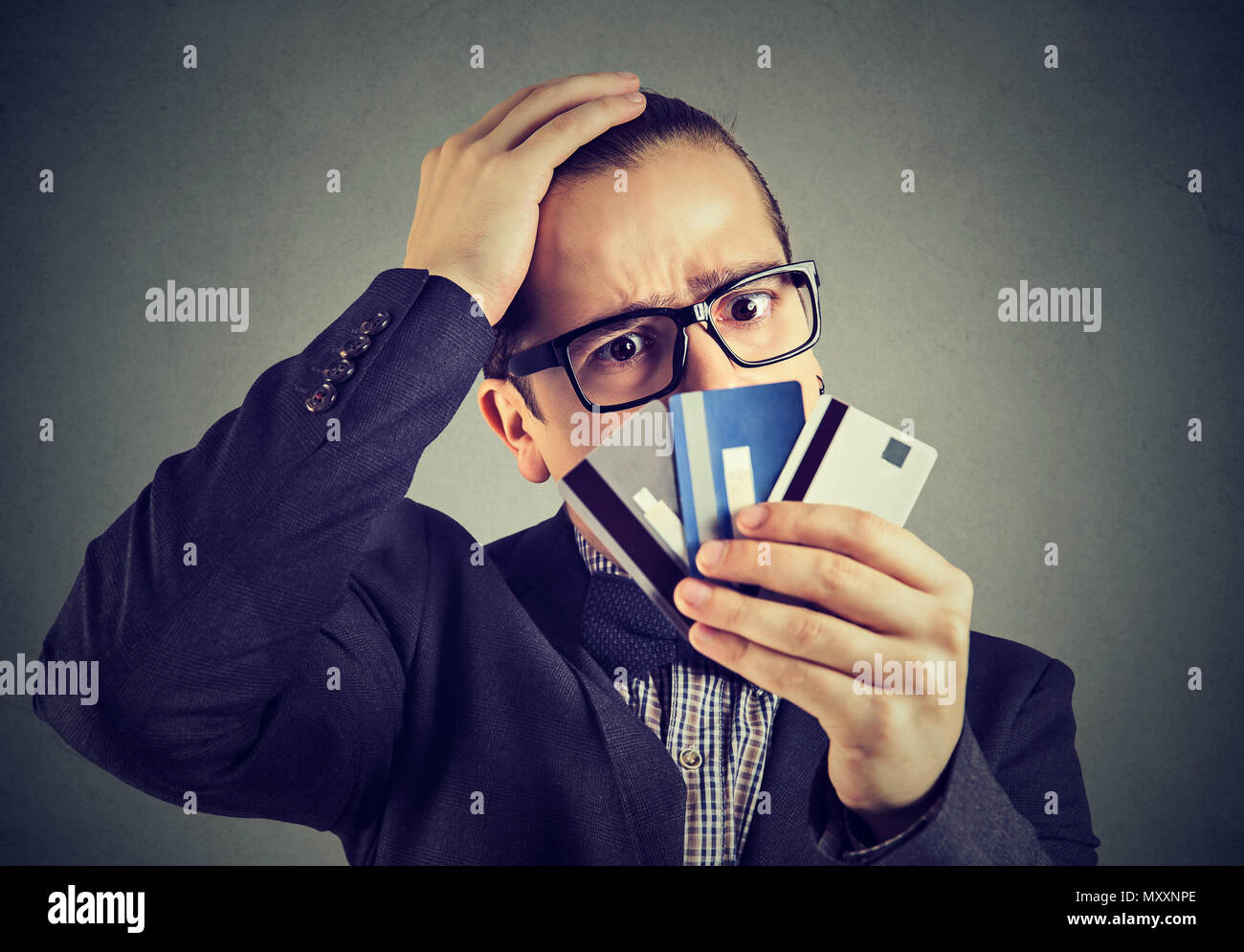 Junge Mann in Gläsern, Kreditkarten und Suchen mit Geld Probleme hervorgehoben. Stockfoto