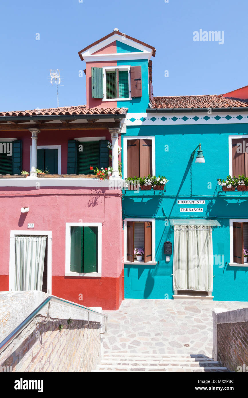 Malerische Häuser in Burano, Venedig, Venetien, Italien mit bunten Lackierung unterteilt in der Mitte einschließlich der obersten Dachfenster Stockfoto
