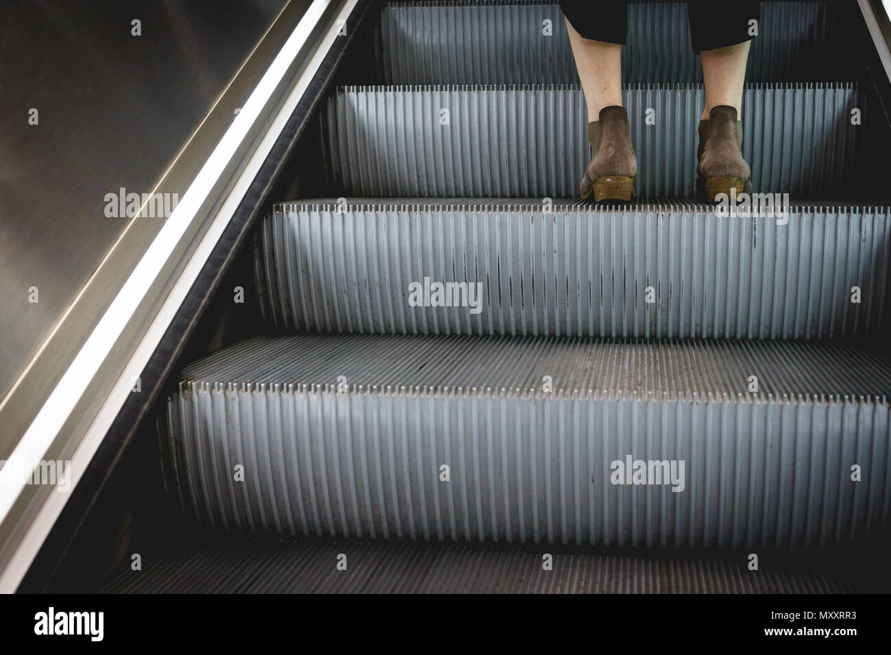 London, UK, September 2017. Unten Beine einer Frau das Tragen von Stiefeln auf ein Schritt der Fahrstuhl stehen. Querformat. Stockfoto