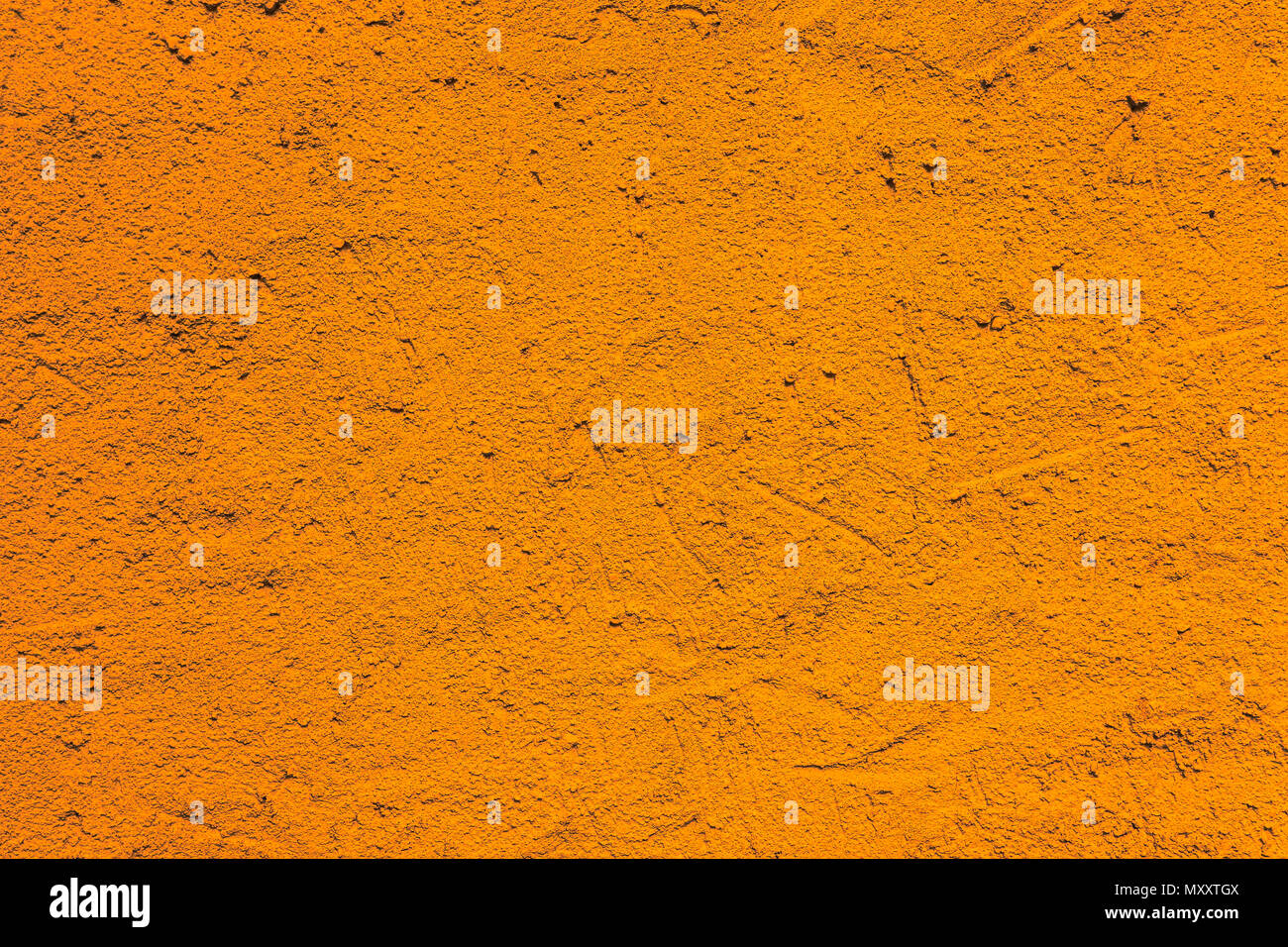 Orange Wand aus einem Haus, grob Außenfassade mit intensiv leuchtenden Farben als leere rustikal und einfach unebenen Stuck Textur Hintergrund. Stockfoto