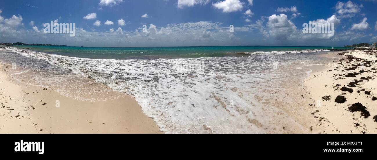 Panorama eines schönen sonnigen Tages am Bayshore / Pebbles Beach (Carlisle Bay) in der Nähe von Bridgetown Barbados (Karibik Insel) - weißer Sand, Wellen, blauer Himmel Stockfoto