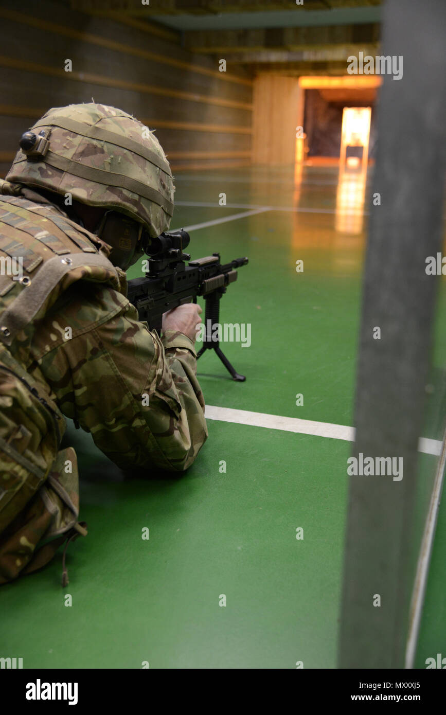 Ein Mitglied der Britischen Streitkräfte, die an die lokalen Einheiten zugeordnet, sich ein Ziel in Bauchlage unterstützt Position während der L 85 A2 rifle Kalibrierung bei der Schulung Support Center Benelux 25 m Reichweite im Innenbereich, in Chièvres Air Base, Belgien, November 30, 2016. Die britischen Truppen unter Aufsicht der britischen Joint European Training Team (USA ausgebildet Armee Foto durch visuelle Information Specialist Pascal Demeuldre) Stockfoto