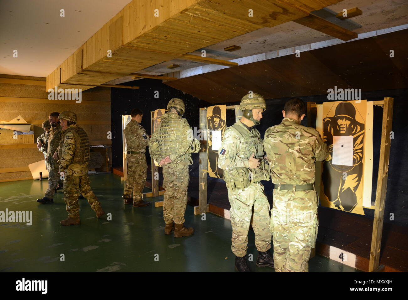 Mitglieder der Britischen Streitkräfte, die zu den lokalen Einheiten zugeordnet, prüfen Ihre Zielgruppe nach dem ersten Nullstellen, während der L 85 A2 rifle Kalibrierung bei der Schulung Support Center Benelux 25 m Reichweite im Innenbereich, in Chièvres Air Base, Belgien, November 30, 2016. Die britischen Truppen unter Aufsicht der britischen Joint European Training Team (USA ausgebildet Armee Foto durch visuelle Information Specialist Pascal Demeuldre) Stockfoto
