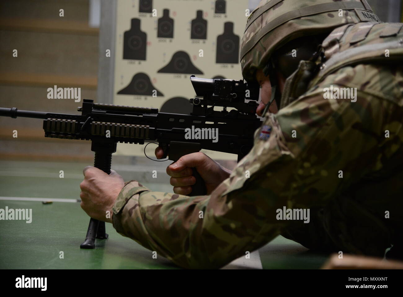 Ein Mitglied der Britischen Streitkräfte, die an die lokalen Einheiten zugeordnet, sich ein Ziel in Bauchlage unterstützt Position während der L 85 A2 rifle Kalibrierung bei der Schulung Support Center Benelux 25 m Reichweite im Innenbereich, in Chièvres Air Base, Belgien, November 30, 2016. Die britischen Truppen unter Aufsicht der britischen Joint European Training Team (USA ausgebildet Armee Foto durch visuelle Information Specialist Pascal Demeuldre) Stockfoto