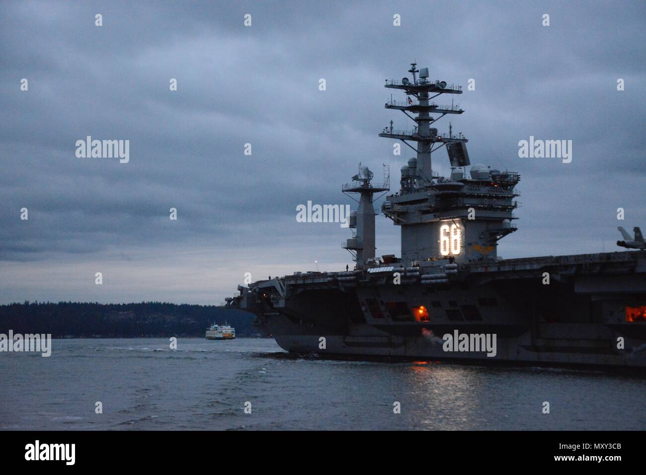 Die USS Nimitz (CVN 68), ein nuklearer Flugzeugträger, durchquert Sinclair Inlet, als sie am 15. Dezember 2016 zu seinem Heimatflughafen in Kitsap-Bremerton, Washington, zurückkehrt. Nimitz absolvierte am 8. Dezember das TSTA/FEP (Tailored Ship's Training Availability and Final Evaluation Problem). Der Flugzeugträger wird von der US Navy unter Commander, Navy Installation Command und Navy Region Northwest betrieben und demonstriert die Einsatzbereitschaft und Fähigkeiten an Bord. Stockfoto