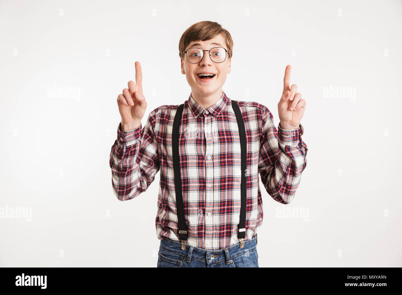 Porträt von einem aufgeregten Jungen Schule nerd Kerl Pointing Finger bis auf weißem Hintergrund Stockfoto
