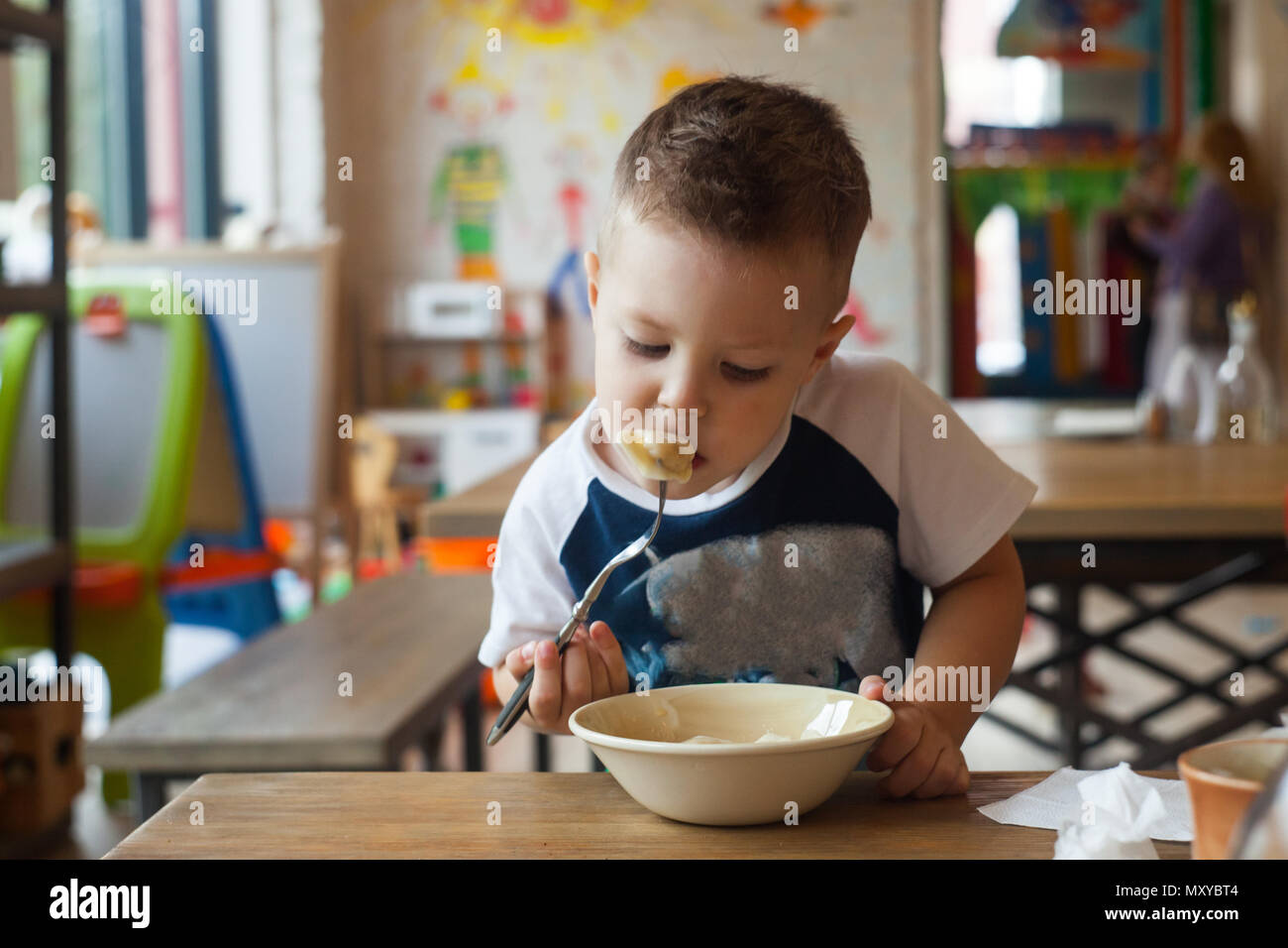 Kleines Kind Junge mit Abendmahl oder Abendessen im Hotel Restaurant oder Cafe. Stockfoto