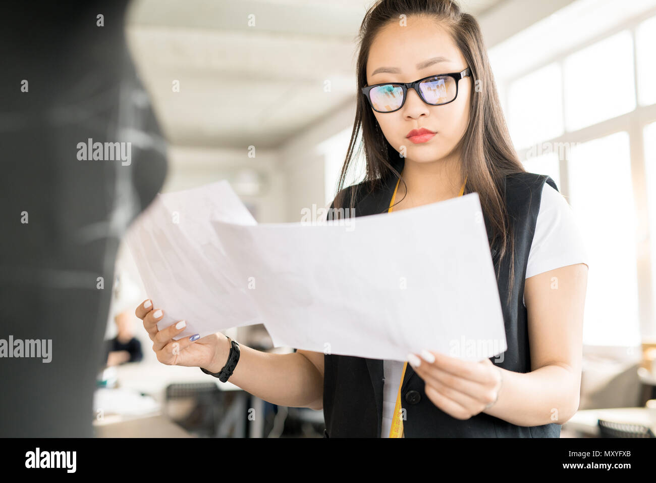 Taille bis Portrait von fokussierten asiatische Frau Brille arbeiten in Fashion Design holding Skizze an Schneider Tabelle durch Nähen dummy in der modernen Stockfoto