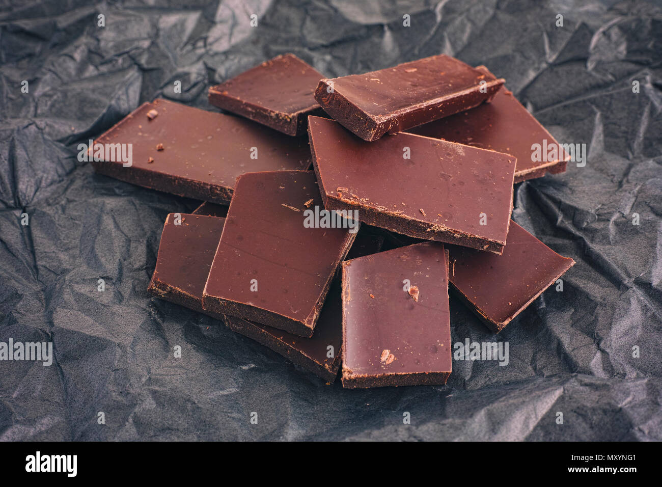 Gebrochene dunkle Schokolade auf schwarzem Hintergrund. Close Up. Stockfoto