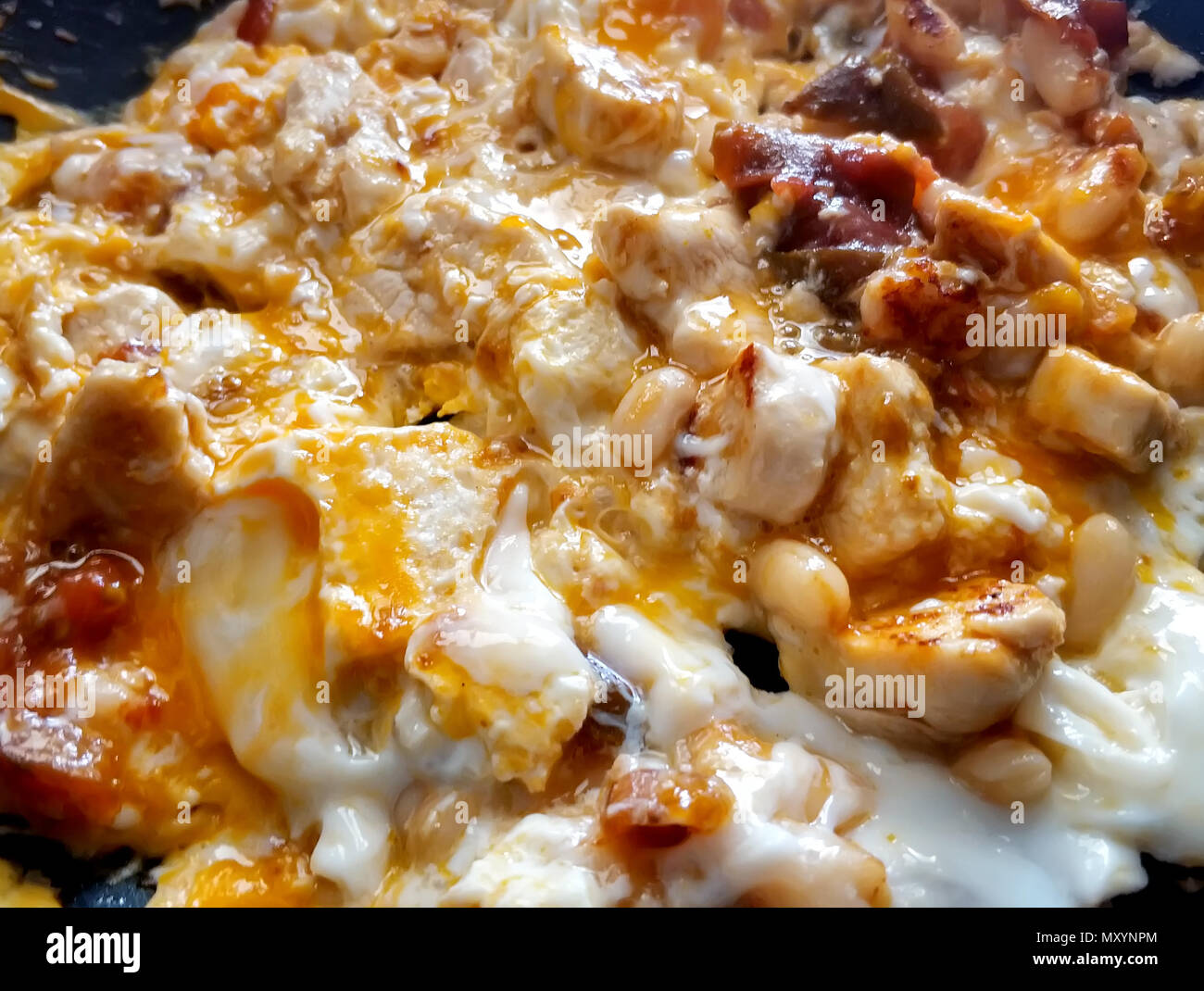 Nahaufnahme einer Spiegeleier mit Geflügel und Bohnen. Reichhaltiges Stockfoto