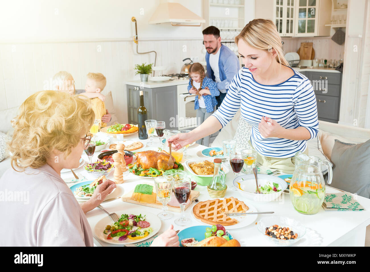 Portrait von großen glücklichen Familie genießen die Zeit zusammen im Speisesaal, auf zwei Frauen bei festlichen Tisch in der modernen lichtdurchfluteten Wohnung konzentrieren Stockfoto