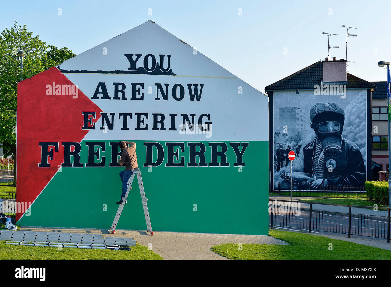 Lokale Künstler Jim Collins Malerei eine palästinensische Flagge auf der ikonischen Free Derry Wand in der Bogside, Derry, Nordirland. Stockfoto