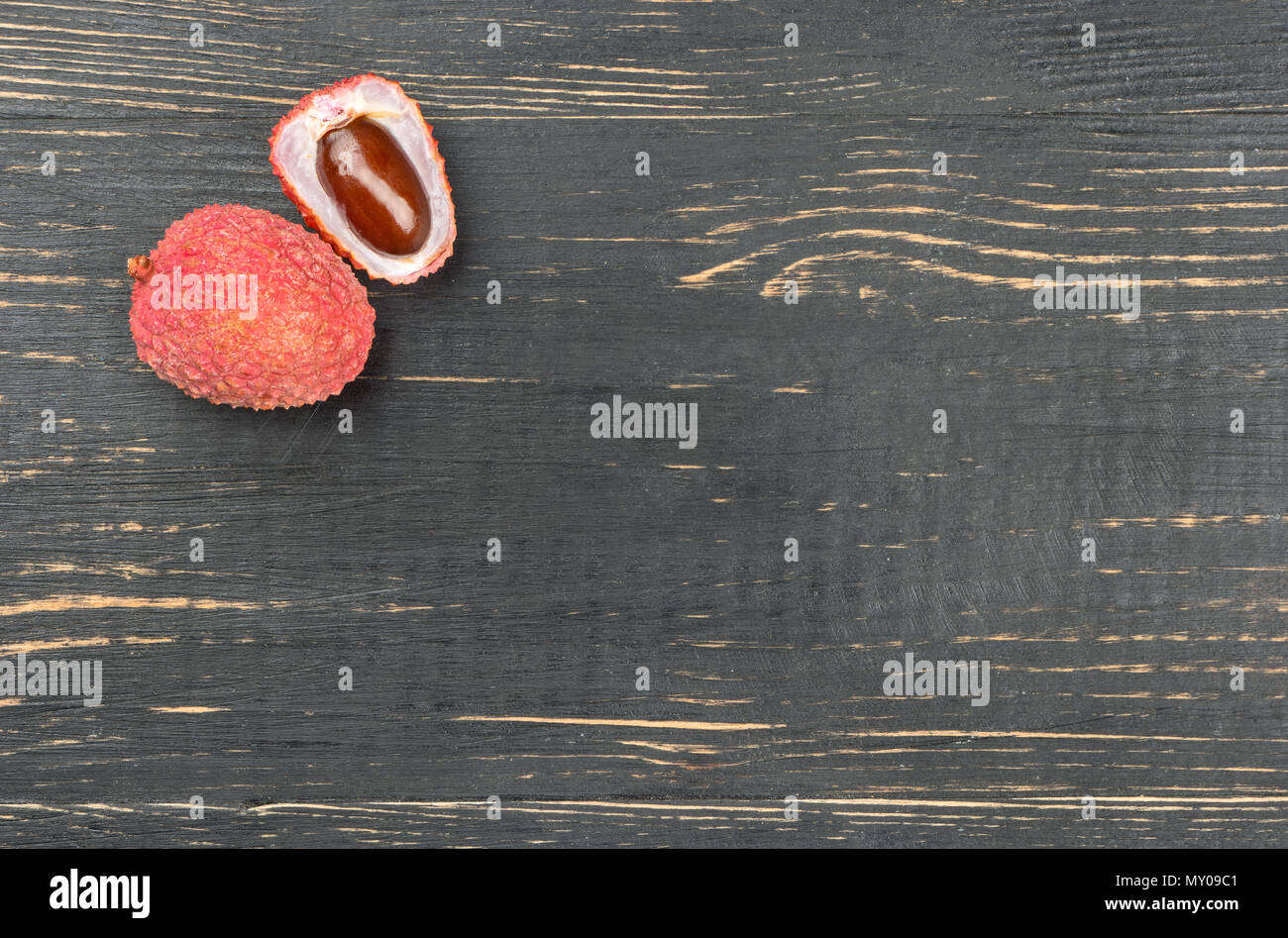Reif lychee Obst in-shell die Hälfte auf eine leere Holz- Hintergrund Stockfoto