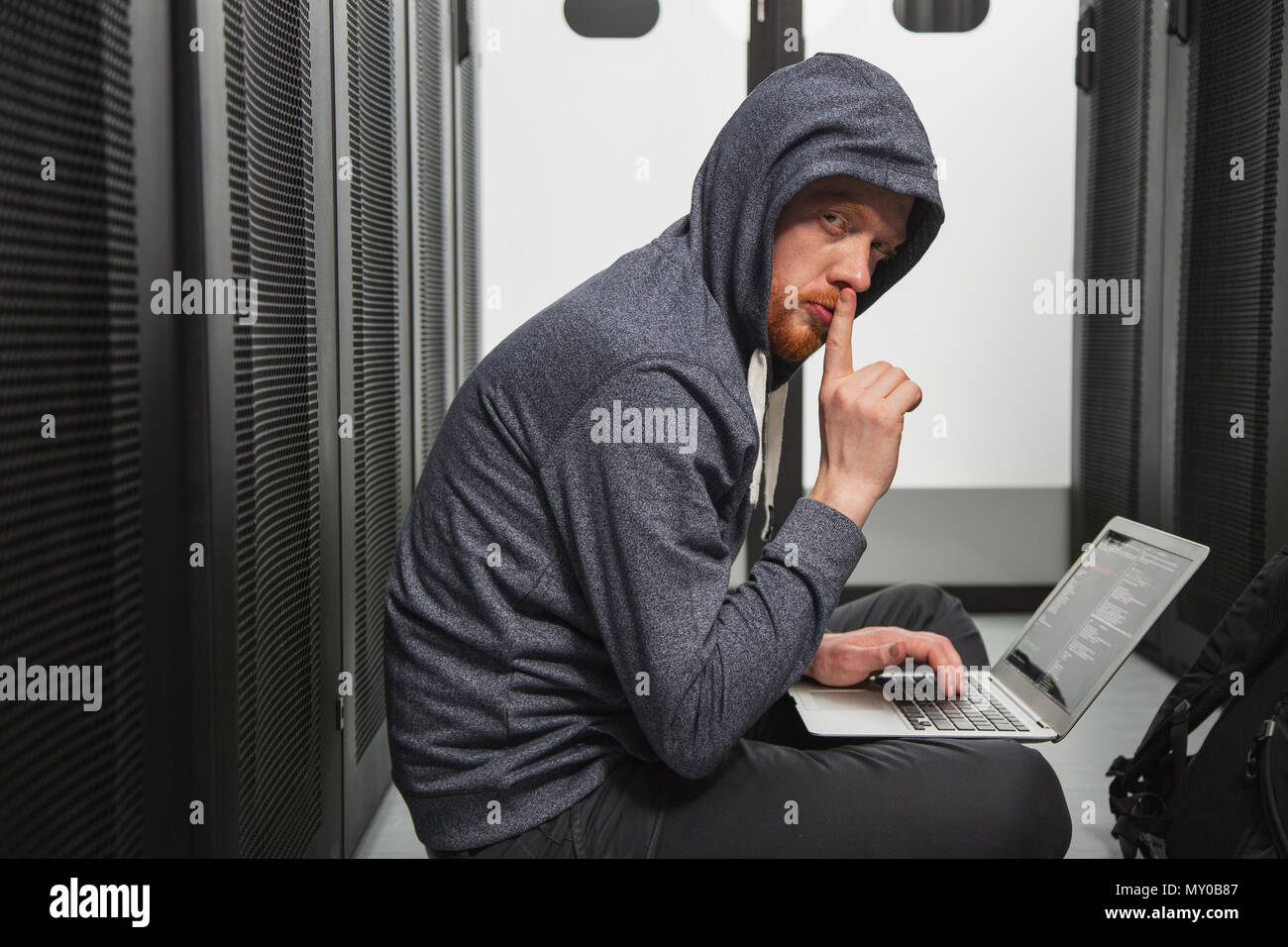 Crafty männliche Hacker knacken Sicherheit Stockfoto