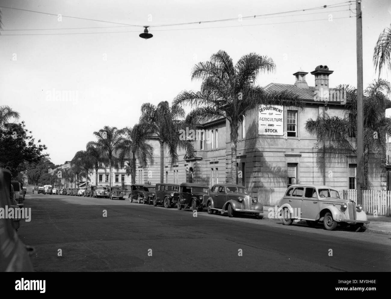 Ministerium für Landwirtschaft und Lager, William Street, Brisbane, 1940. Von der Queensland Erbe Registerid=601093). Die ehemalige Abteilung der primäre Industrien Gebäude, gebaut in unbemalt Rendern und gemalte Mauerwerk, liegt auf einem steil abfallenden Gelände mit zwei Stockwerken und Keller fronting William Street und einen unteren drei-stöckigen Flügel am Heck fronting Queen's Wharf Road gebaut. mit einem walm Rippe und Pan verzinktem Eisen Dach. Das Gebäude wurde ursprünglich erbaut als Einwanderung Depot und Bau im Jahre 1865 begonnen und 1866 abgeschlossen. Das Gebäude wurde auf einem Teil der für Stockfoto